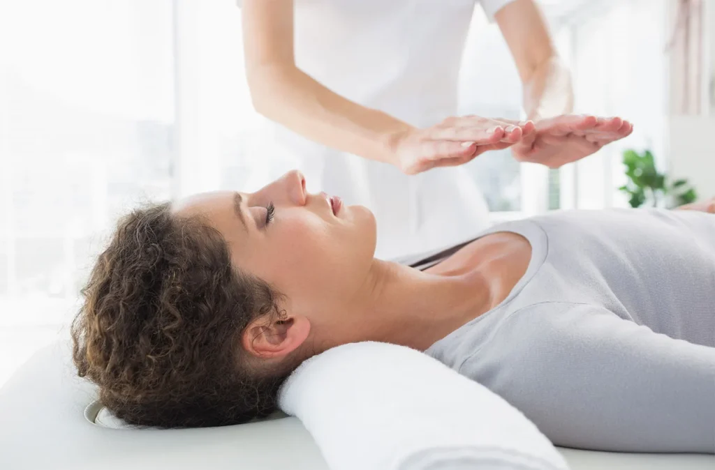 woman having reiki treatment laying of hands of person japanese alternative medicine